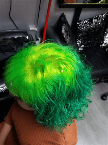 A customer with a bright green haircut