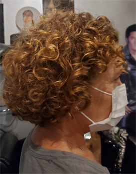 A customer with a curly light brown haircut