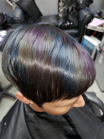 A customer with a dark brown haircut with rainbow highlights