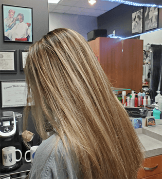 A customer with a long brown and blonde haircut