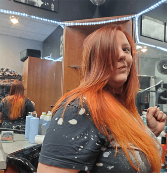 A customer with a long orange haircut