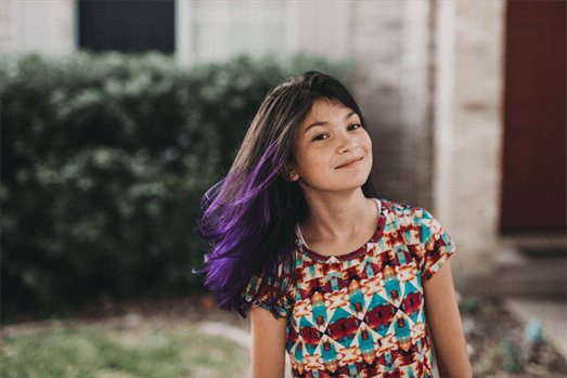 A customer with a long purple ombre haircut