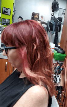 A customer with a long red ombre haircut