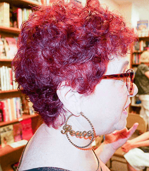 A customer with a short red and purple haircut